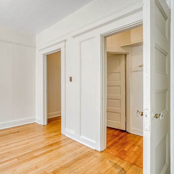a room with white walls and wooden floors with two doors at clay & tiffany, portland, 97201