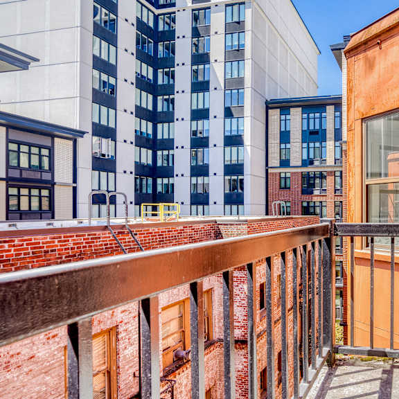 a balcony with a metal railing overlooks a brick building at clay & tiffany, portland, 97201