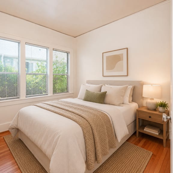 a bedroom with a bed, nightstand, and window.