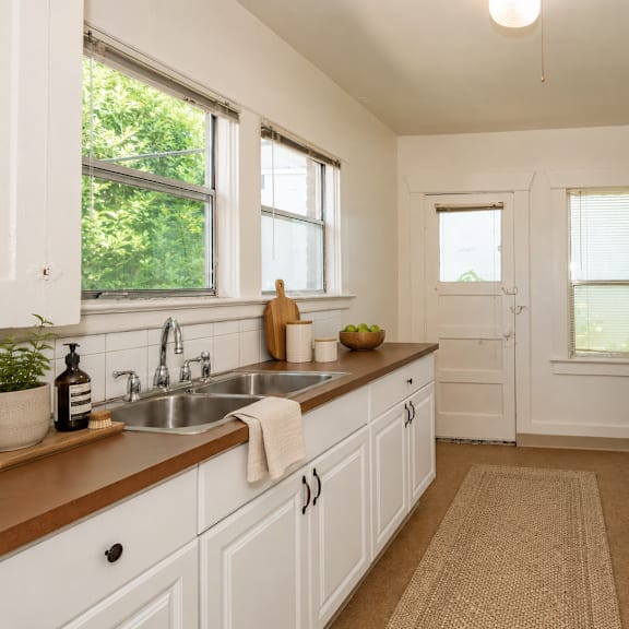 a kitchen with white cabinets and a white fridge.