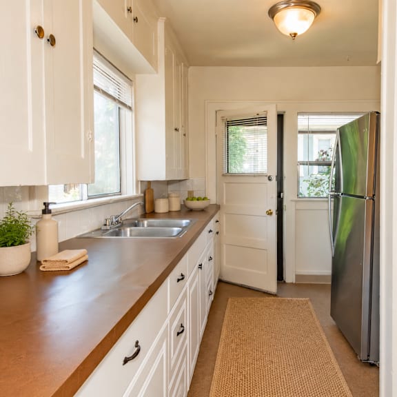 a kitchen with white cabinets and a brown countertop.