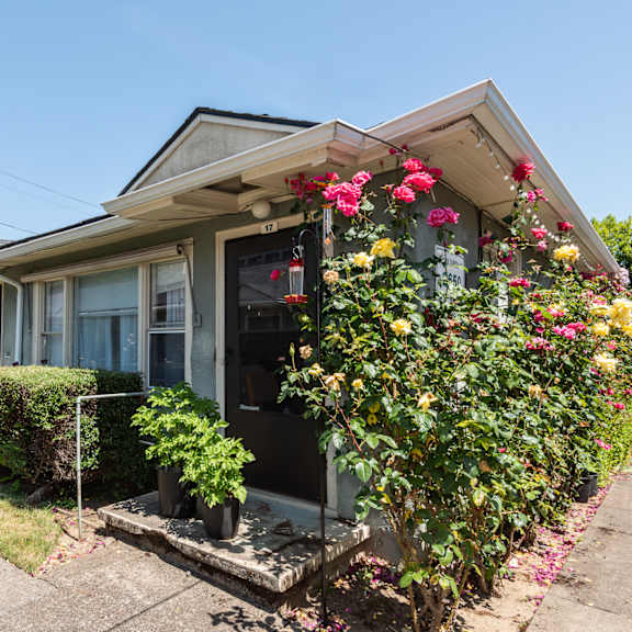 a house with a grey roof and a flower box on the front.