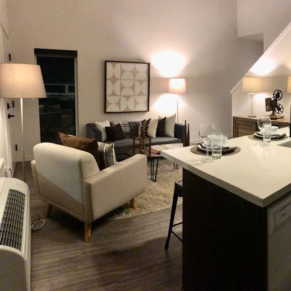 a modern kitchen with a dining area and a living room.