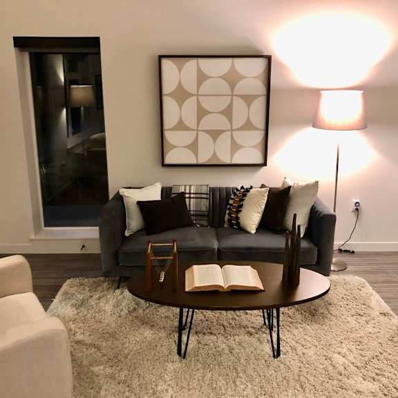 a living room with a grey couch and a coffee table.