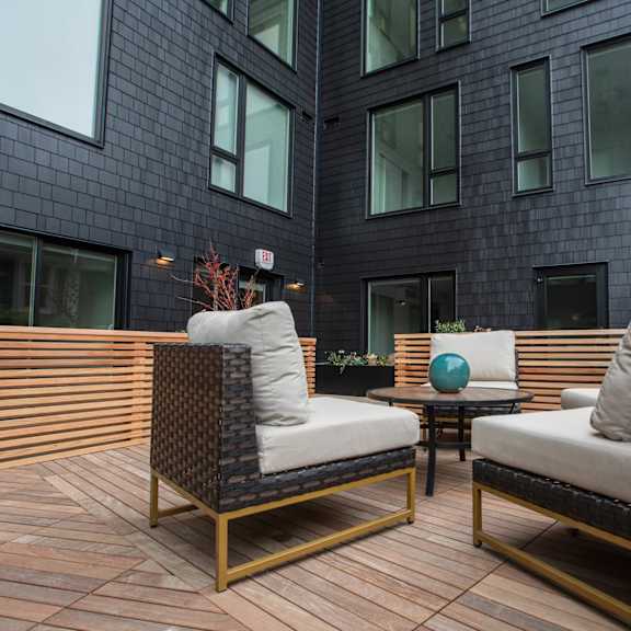 a patio with chairs and a table in front of a building at analog tacoma, tacoma