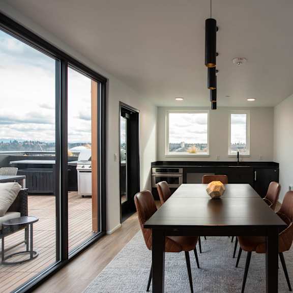 a dining room with a table and chairs and sliding glass doors at analog tacoma, tacoma, wa