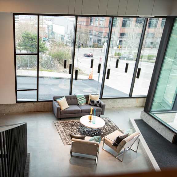 a living room with couches and a table in a building with large windows at analog tacoma, tacoma, wa, 98402
