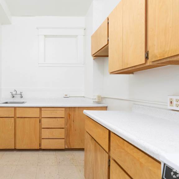 a small kitchen with white walls and wooden cabinets at clay & tiffany, portland, or, 97201