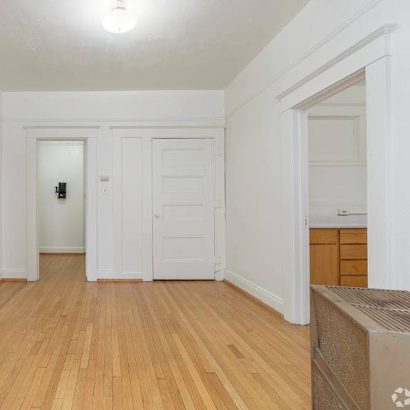 a living room with white walls and doors and a wood floor at clay & tiffany, portland, or, 97201