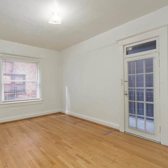 the living room of an empty home with white walls and wood floors at clay & tiffany, portland, or