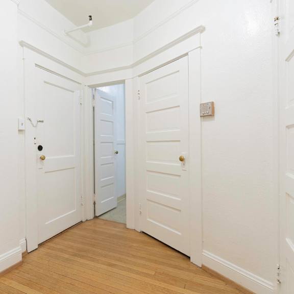 a white hallway with white walls and a door with a black box on the wall at clay & tiffany, portland, or