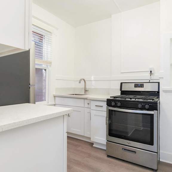 a white kitchen with stainless steel appliances and white cabinets at clay & tiffany, portland, or