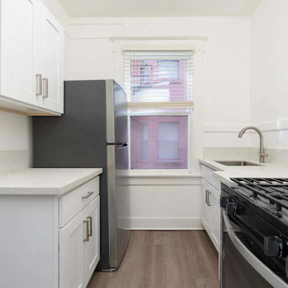 a kitchen with white cabinets and a stove and a window at clay & tiffany, portland, 97201