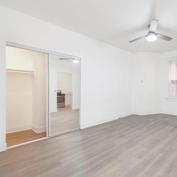 an empty living room with a mirrored closet and a ceiling fan at clay & tiffany, portland, 97201