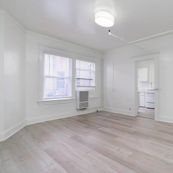 an empty living room with white walls and a window at clay & tiffany, portland, or, 97201