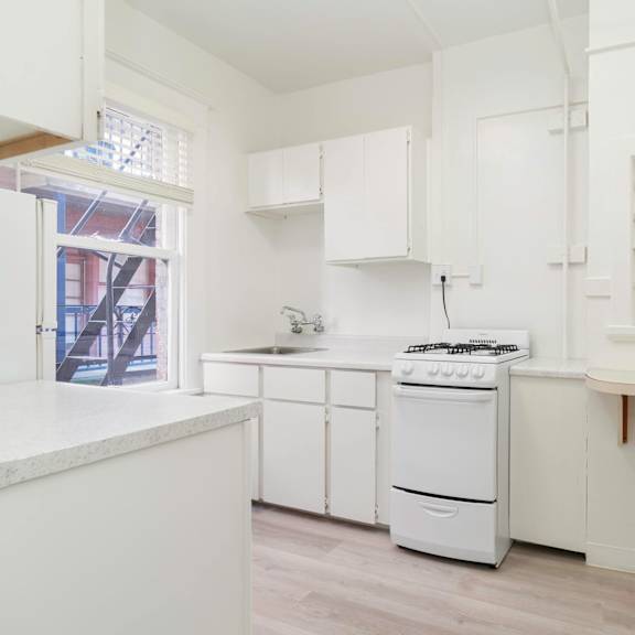 a white kitchen with a stove and a window at clay & tiffany, portland, or