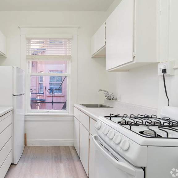 a white kitchen with a stove and a window at clay & tiffany, portland, or