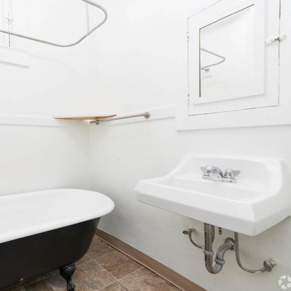 a white bathroom with a black bath tub and a sink at clay & tiffany, portland, or