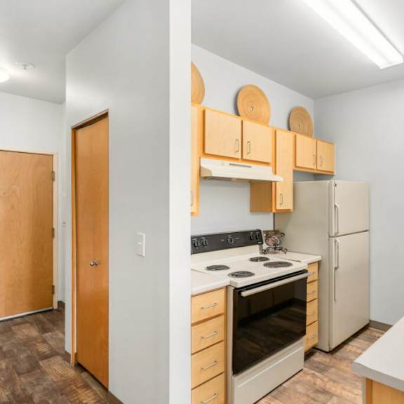 a kitchen with a white counter top and a white refrigerator.at fifth avenue place apartments, oregon