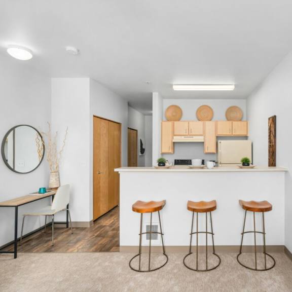 a modern kitchen with a bar area and stools.at fifth avenue place apartments, portland, or