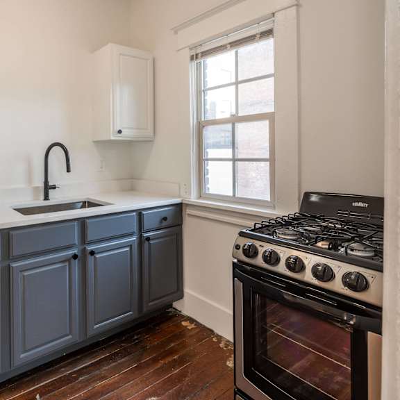 a kitchen with a stove and a window at midtown apartments, oregon