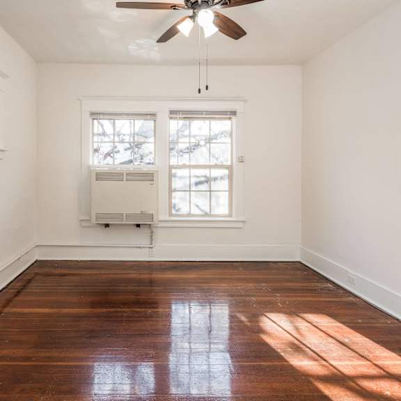 a room with a ceiling fan and two windows at midtown apartments, portland