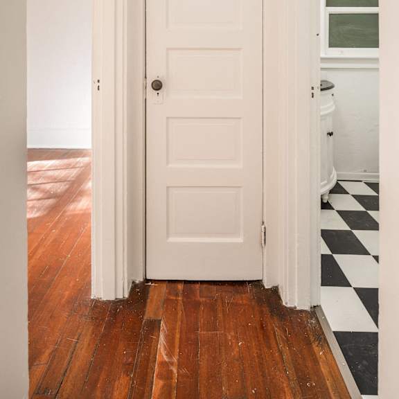 a white door is open to a room with a black and white checkered floor at midtown apartments, portland, 97209