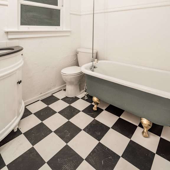 a white bathroom with black and white checkered floor at midtown apartments, oregon
