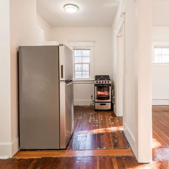 a kitchen with a refrigerator and a microwave at midtown apartments, portland, or, 97209