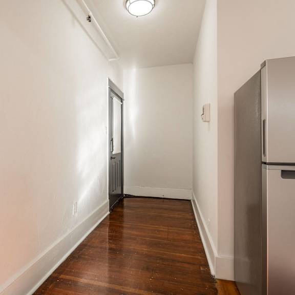 a long hallway with a checkered floor and a refrigerator on the right at midtown  apartments, portland, or