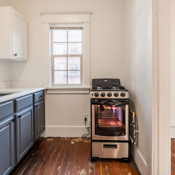 a wood stove is in a kitchen with white walls at midtown apartments, portland