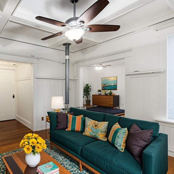 a living room with a green couch and a ceiling fan at midtown  apartments, portland, or