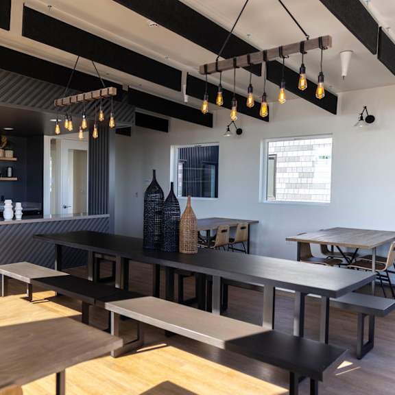 a dining room with tables and benches and a kitchen in the background at moraine, tacoma, washington 98402