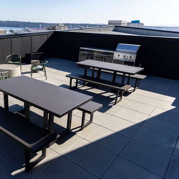 tables and chairs on the rooftop of a building with a city in the background at moraine, washington 98402