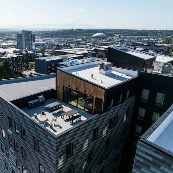 a building with a rooftop terrace and a city in the background at moraine, tacoma, washington