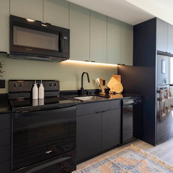 a kitchen with black cabinets and a sink and a microwave at moraine, tacoma, washington