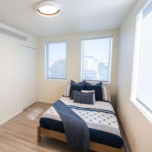 a bedroom with a bed and three windows at moraine, tacoma, wa