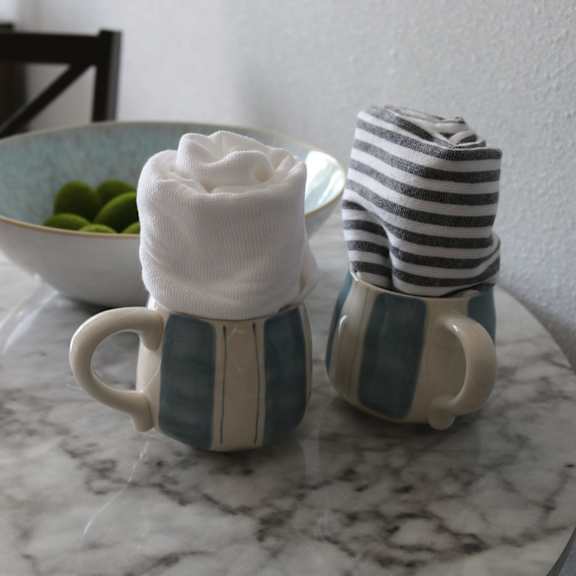 two coffee mugs with towels and a bowl of fruit on a table at schaefer ridge apartments, missouri, 65616