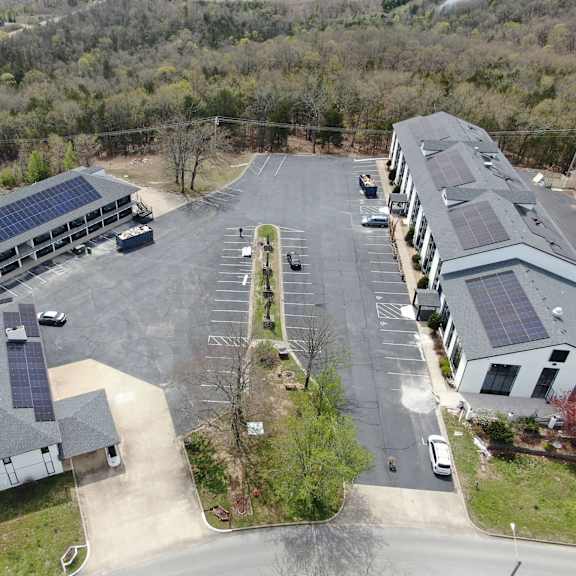 an aerial view of a building with solar panels on the roof at schaefer ridge apartments, branson , mo