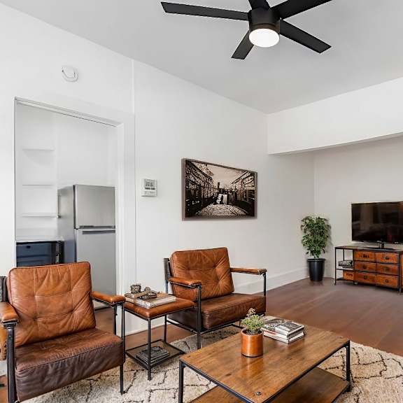 a living room with a brown leather chair and a brown leather couch.