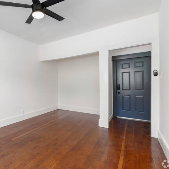 a room with a ceiling fan and a door.