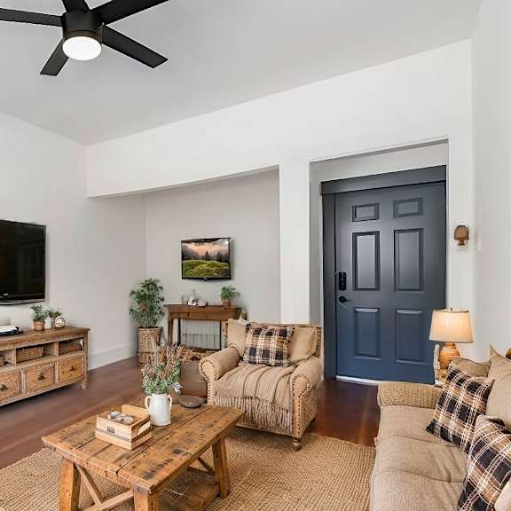 a living room with a blue door and a television on the wall.