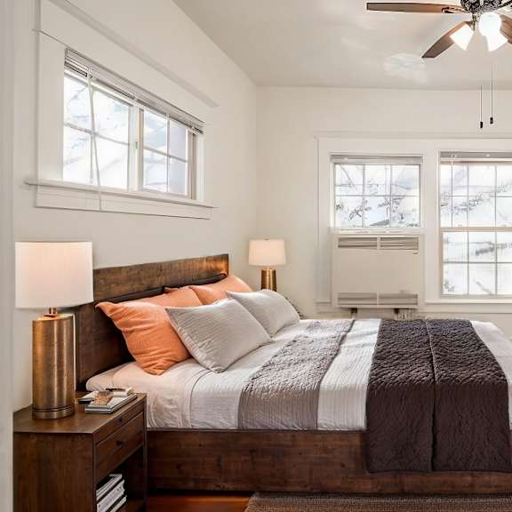 a bedroom with a bed, nightstand, and a ceiling fan.