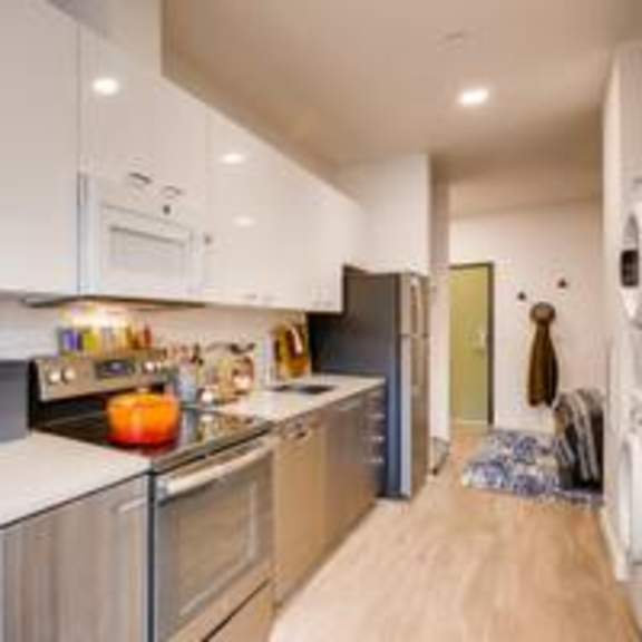 a kitchen with a stove top oven next to a refrigerator at holm at sellwood, oregon