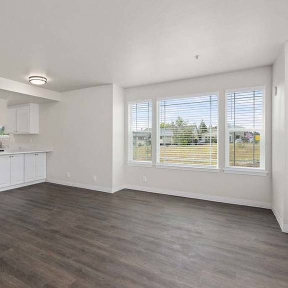 an empty kitchen and living room with a large window