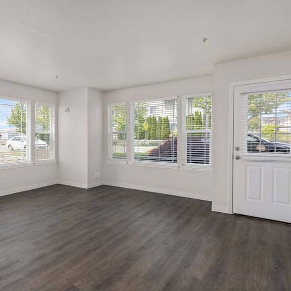 an empty living room with white walls and a white door