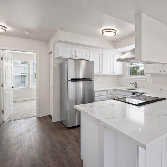 a kitchen with a white counter top and a refrigerator