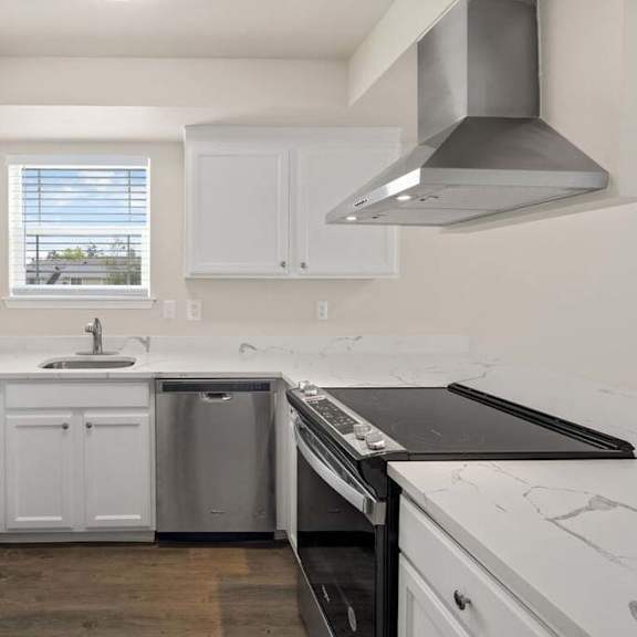 a kitchen with a stove top oven next to a refrigerator