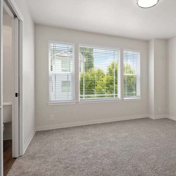 a bedroom with three windows and a door