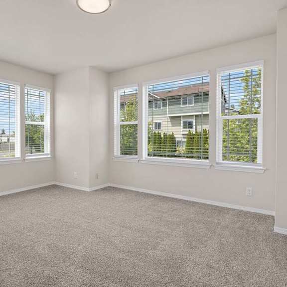 a bedroom with four windows and a carpeted floor